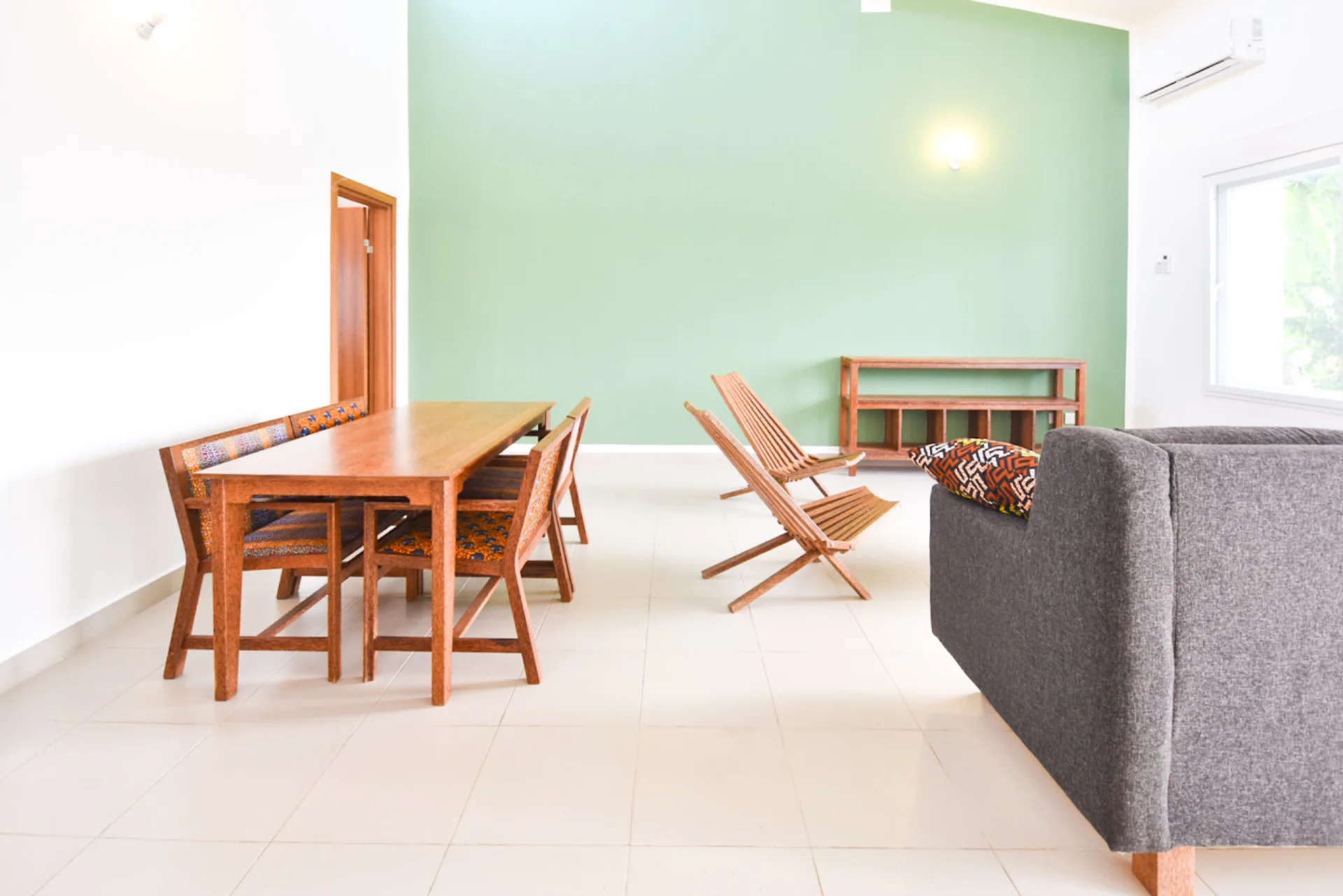 Timber dining table and chairs beside the bright green living room wall.